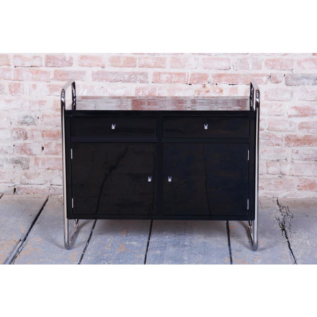 This elegant cabinet from the early 20th century was crafted by the renowned Czechoslovak manufacturer Robert Slezák. Its...