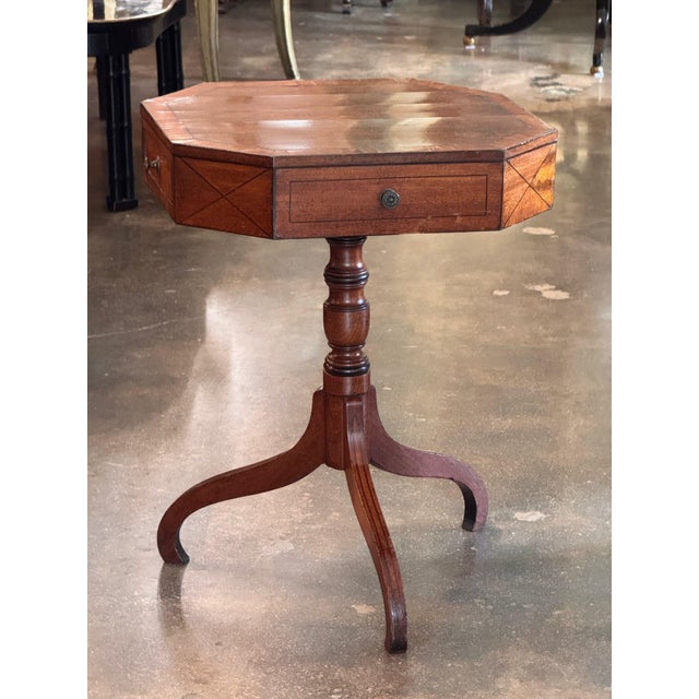 Early 19th century English Regency mahogany work table with an octagonal top and canted corners, crossbanded around the...