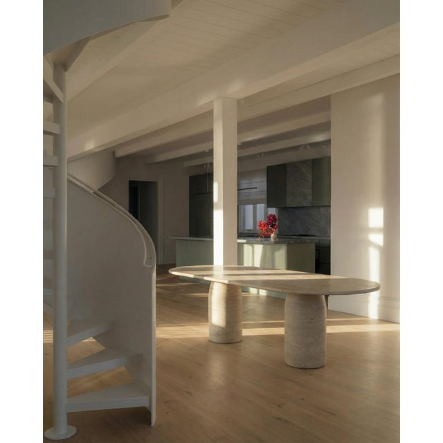 This minimalist table is crafted entirely from a single material, featuring a beautifully curved-edge top in natural...