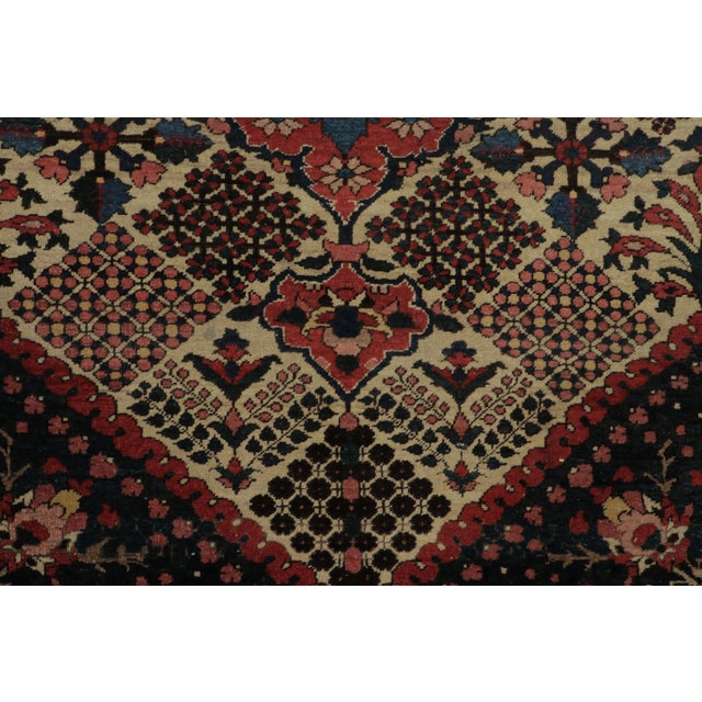 Hand-knotted in wool and originating circa 1910-1919, this 4x6 antique Persian rug features a bold floral medallion set...