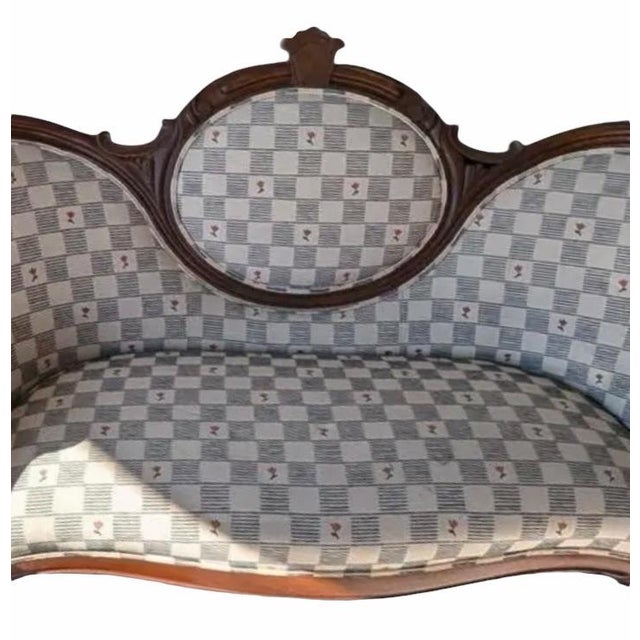 A charming late 19th-century Victorian balloon-back settee crafted in solid walnut, featuring graceful curves, carved...