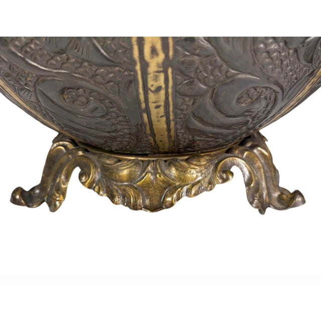 Pair of decorative table lamps crafted from embossed and formed brass sheet, featuring globe-form bodies with elaborate...