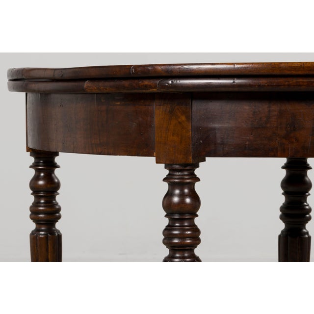 An elegant late 19th century Country French Provincial folding demilune table in the Louis Philippe style, sourced from...