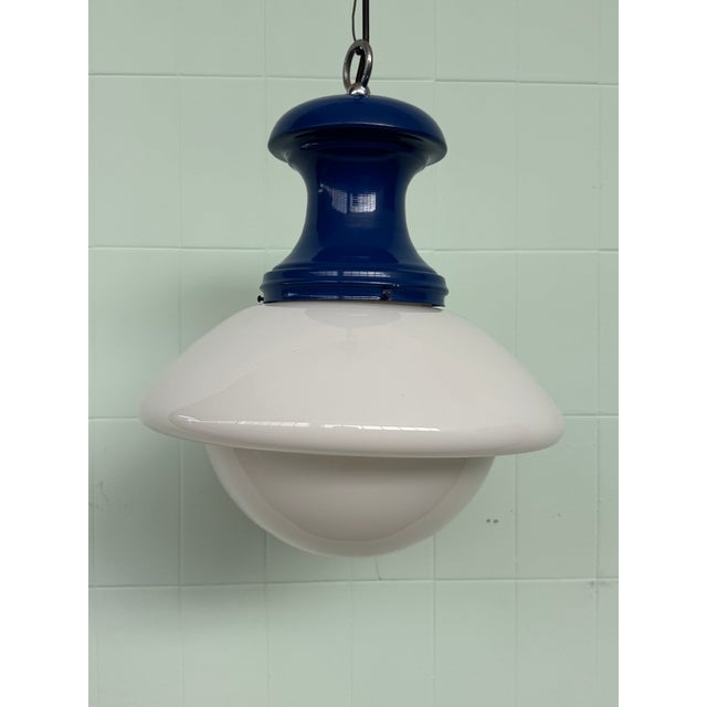 Vintage 1970s chandelier featuring a Space Age-inspired, industrial design. It features a curved lower diffuser in glossy...
