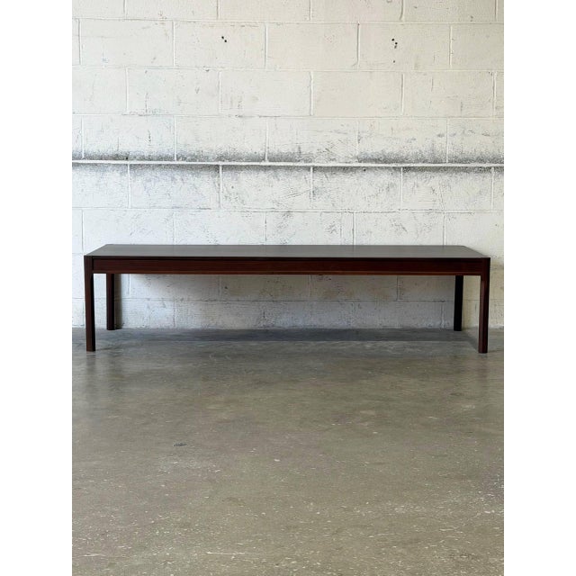 This striking rectangular coffee table features clean architectural lines and an expansive surface. The streamlined...