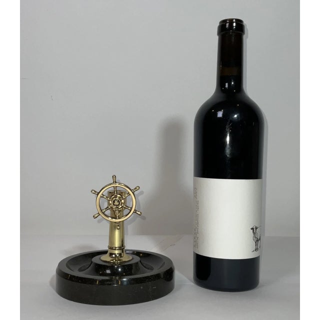 Nautical cigar cutter with a hole and cutting blade in the column. When the wheel is turned, the blade is engaged to cut...