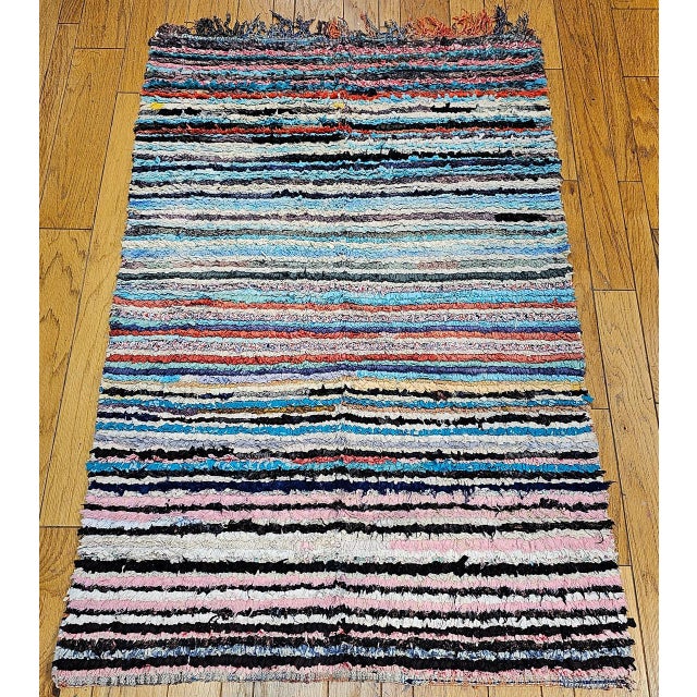 This striking vintage Moroccan Boucherouite rug from the third quarter of the 20th century is a work of exuberant abstract...