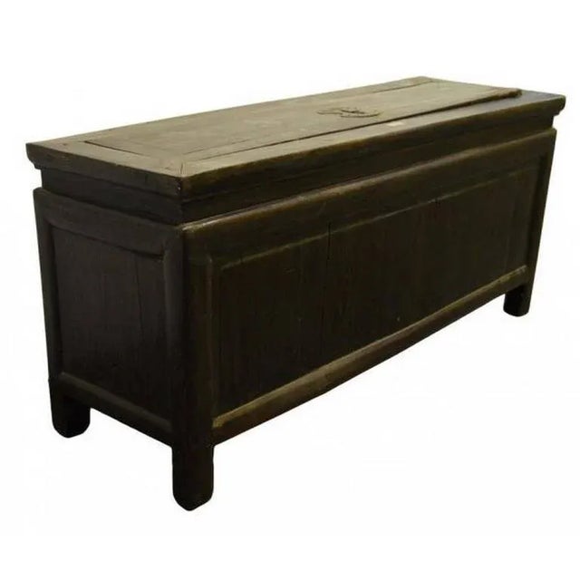 A Chinese antique lacquered trunk from the 19th century. This 19th century antique Chinese trunk displays a brown lacquer...