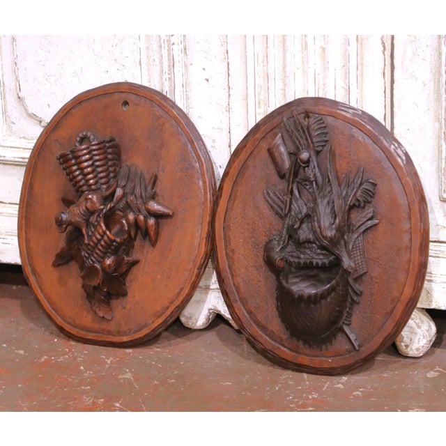 This distinctive pair of antique Black Forest wall plaques was hand-carved from solid walnut in France circa 1870. Each is...