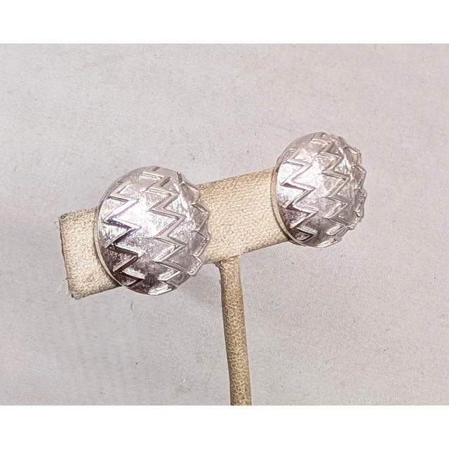 1960s round domed rhodium plated zig zag clip earrings. Marked crown "TRIFARI©" on the clips. Measure: 7/8 inches across....
