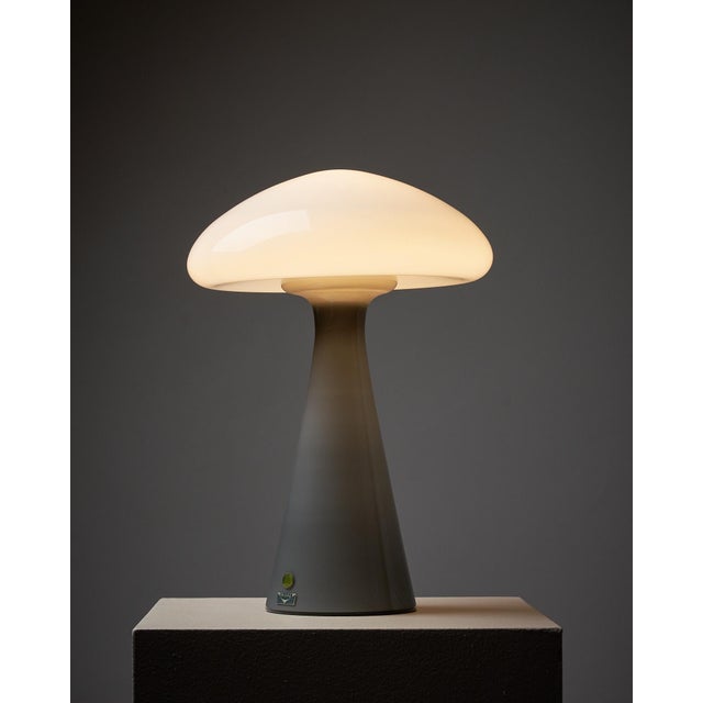 Introducing a unique table lamp by Vistosi, showcasing exceptional craftsmanship and design. This striking piece features...