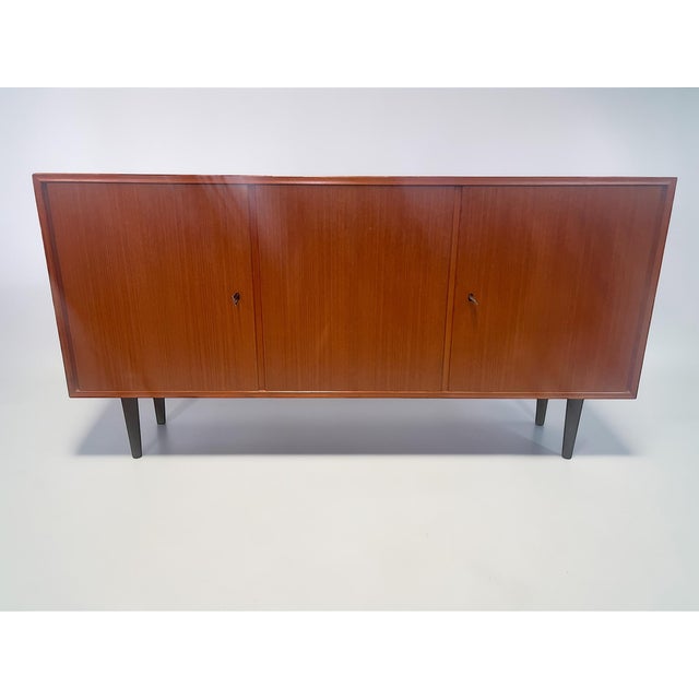 This elegant mid-century sideboard comes from the renowned german furniture manufacturer heinrich riestenpatt kg...