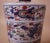 Antique hand-painted jar with dragons, phoenixes and florals in hues of red, blue, yellow and green over white background....