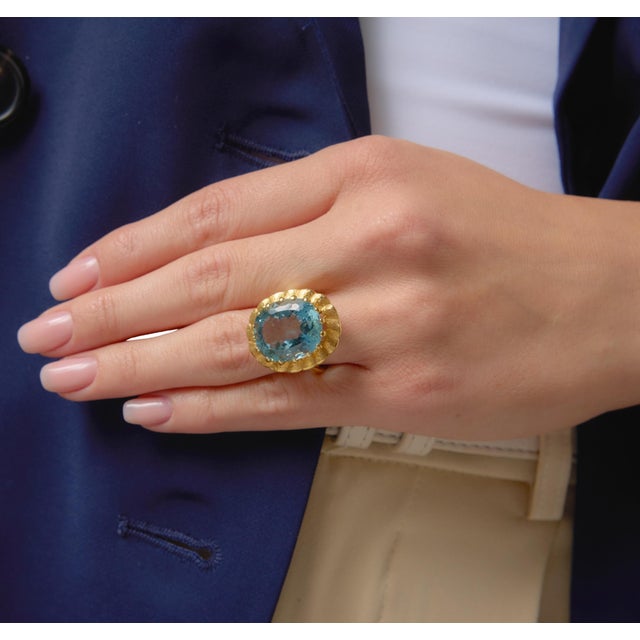 This bold vintage cocktail ring showcases a striking oval cut aquamarine weighing approximately 14.00 carats, radiating a...