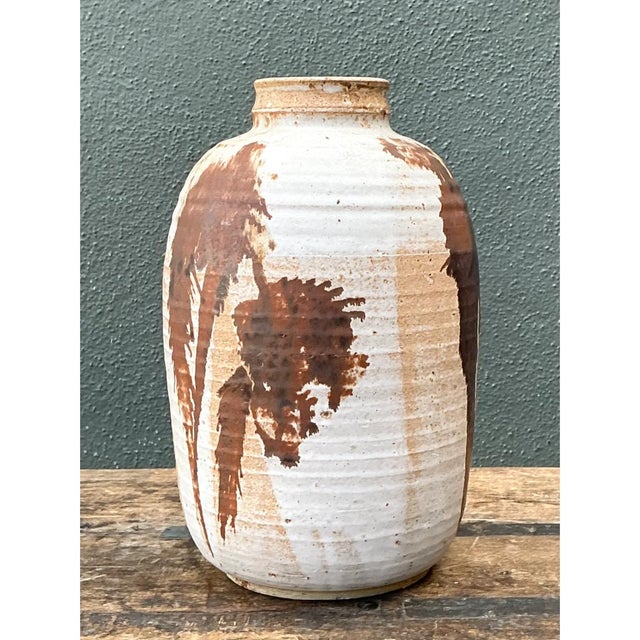 This vintage abstract stoneware vase presents a robust, hand-thrown silhouette, its cylindrical body gently tapering from...