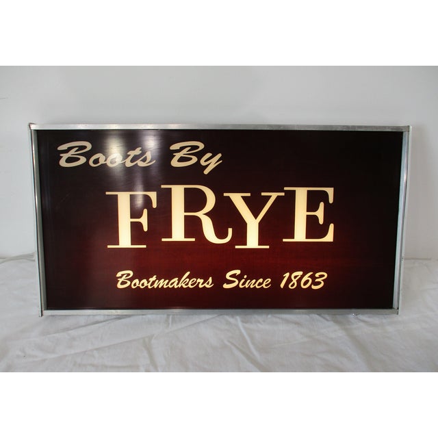 A 1970's vintage advertising light up hanging sign for Frye Boots stating " Boots by FRYE Bookmakers Since 1863". Black...