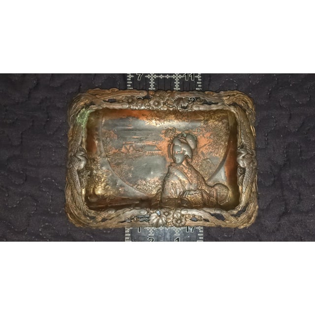 Vintage Japanese mixed-metal plaque featuring a finely detailed geisha figure within a scenic temple and landscape. Hand-...