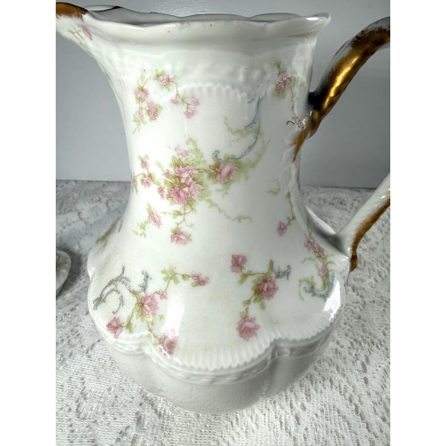 A beautiful Haviland Limoges porcelain chocolate/tea pot featuring soft hand‑painted pink roses and delicate gold trim....