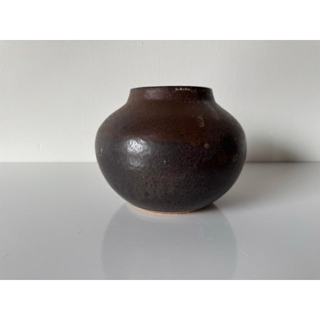 This beautiful 1980’s vintage studio pottery vase features an organic, rounded form with a softly tapered neck and a rich,...
