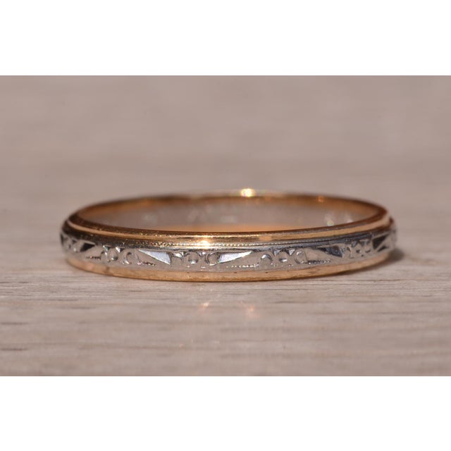 The Greenway Road: Antique Palladium and Yellow Gold Band. The band features a hand carved patterned palladium center with...