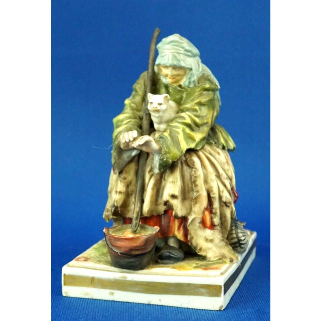 Antique hard-paste porcelain sculpture, polychrome and vitrified, depicting a charming old beggar seated with a pot and a...