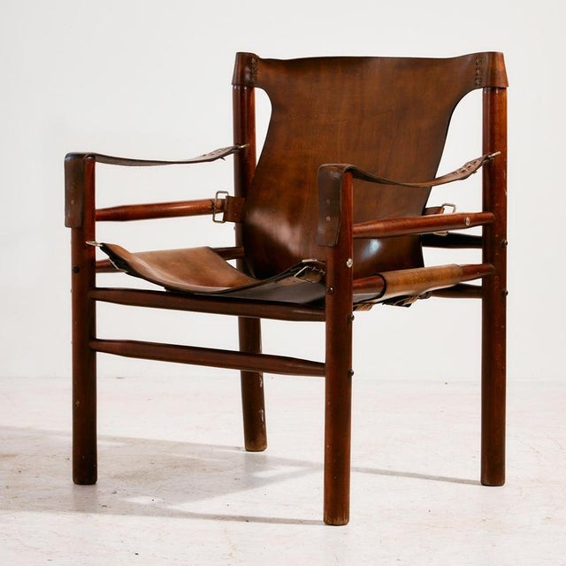Hungarian calf leather lounge chair and ottoman from the 1970s. The wooden and leather surfaces of the set have scratches,...