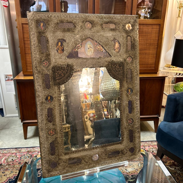 Very cool handmade mirror in tin metal frame. It has inset hand painted figures surrounded by floral motifs. The tin is...