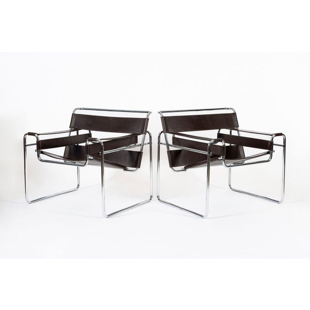 These vintage mid-century modern brown Wassily arm chairs designed by Marcel Breuer and manufactured by Knoll are circa...
