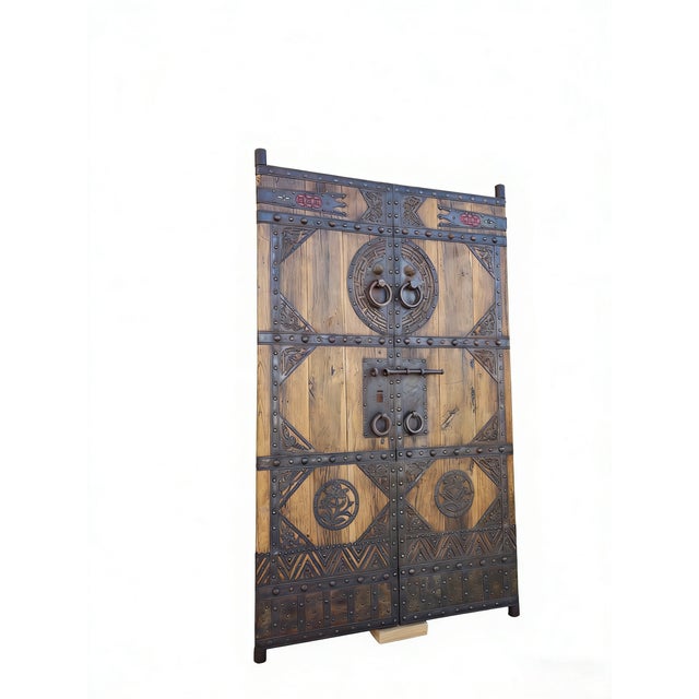 This pair of antique Chinese door panels showcases a blend of traditional craftsmanship through its rustic wood and...
