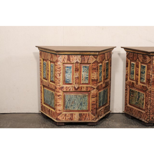 An Italian pair of faux-marble painted, wood demi console cabinets from the 18th century. This antique pair of cabinets...