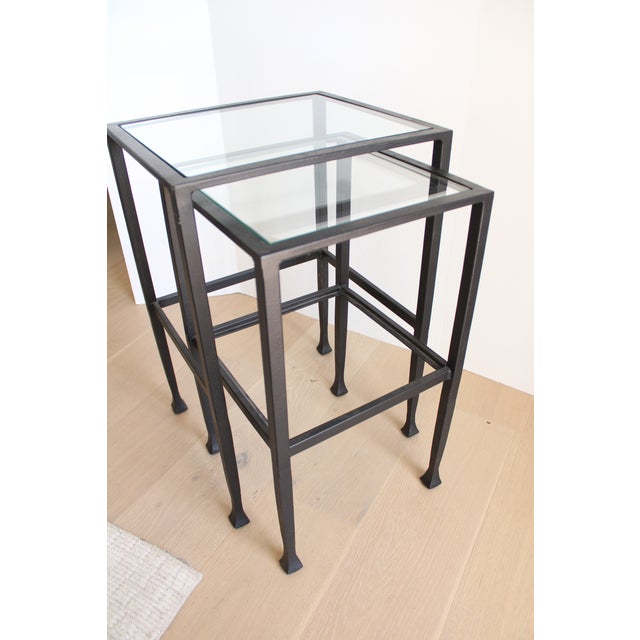 Contemporary pair of iron nesting table's. The frame is handcrafted from iron that is cast and forged by artisans to...