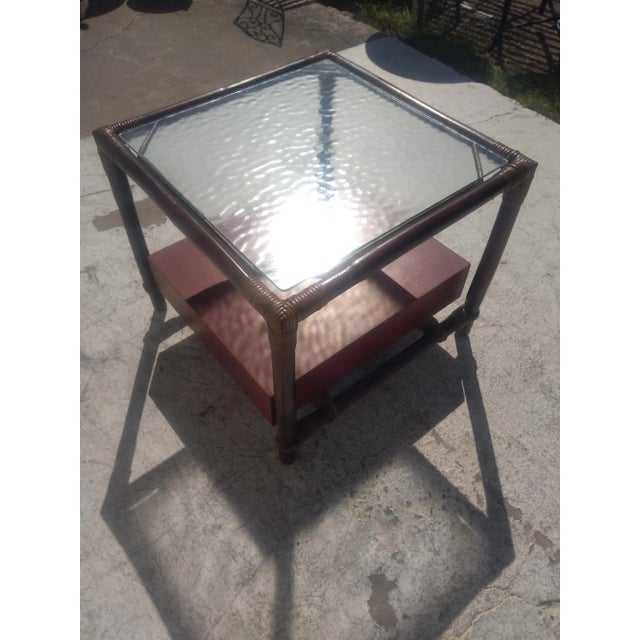 This is a nice boho chic end table by Ficks Reed. It's designed by John Wisner. It has a lower bottom drawer that also...
