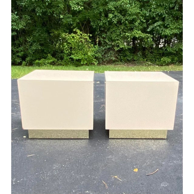 A modernist custom pair of 1990’s Milo Baughman style square lacquered laminate end tables in a light almond beige color...