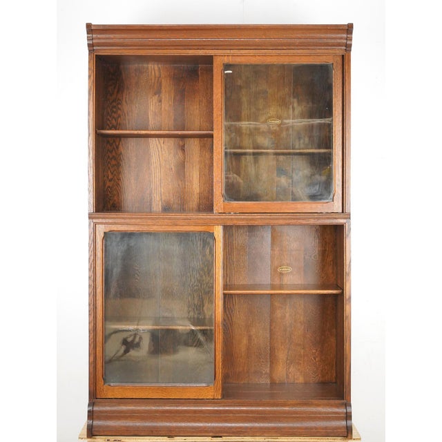 Antique oak barrister bookcase with two sections that feature clear sliding glass doors. Each section has one adjustable...