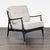 This stylish lounge chair from Anthropologie features a sleek black wood frame with brass accents on the arms and legs....