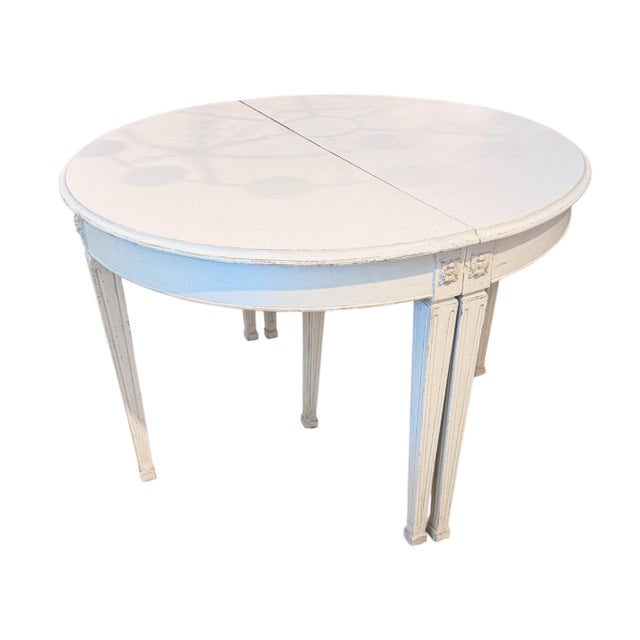 A handsome Swedish painted extension dining table forming a round when closed and expanding to seat a large gathering with...