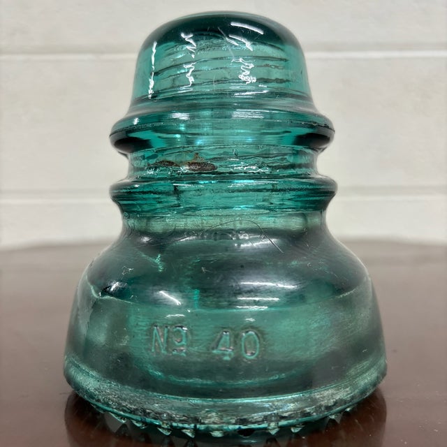 This is a gorgeous antique teal glass Hemingray No. 40 insulator, embossed “HEMINGRAY – No. 40 – U.S.A.”. Produced by the...
