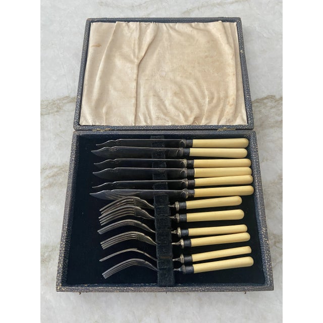 Vintage fish cutlery set by Harrison Fisher & Co. of Sheffield, England. Ivorine handles with engraved silver plate blades...