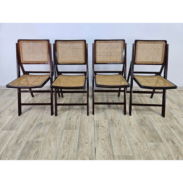 A set of four folding chairs from the 1970s with a simple and timeless form. The structure is made of wood, the seat and...