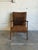 This vintage lounge armchair features an angled frame with sculptured armrests and a tufted backrest. The design...