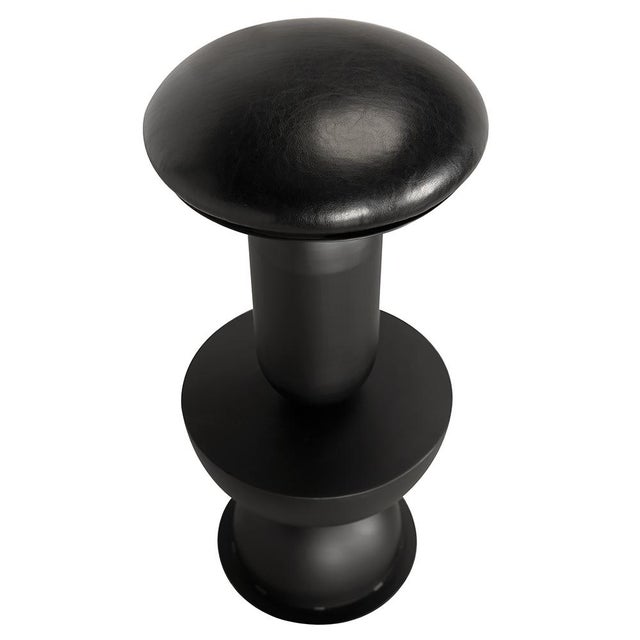 This sculptural swivel bar stool features a bold geometric design comprising stacked symmetrical shapes: a dome, cylinder,...