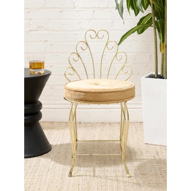 A charming vintage accent chair featuring an airy brass-tone metal frame with an elaborate scrolling backrest. Graceful...