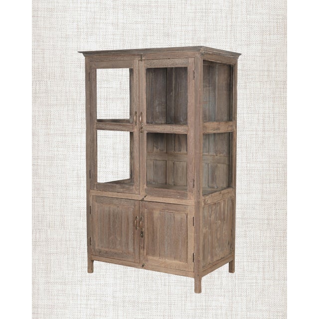 A cabinet that has held things. Books, brass vessels, folded clothes, the quiet accumulation of a life well-lived. This...
