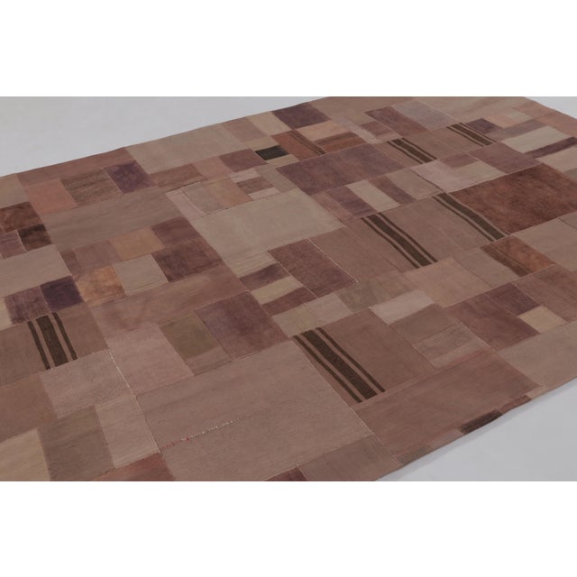 Handwoven in wool circa 1950–1960, this 7x10 vintage Anatolian patchwork rug is a refined addition to Rug & Kilim’s...