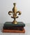 Vintage brass fleur-de-lis candlestick holder with a distressed metallic finish. No makers mark. Some patina.