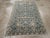 This mid-20th-century Persian Malayer throw rug presents a finely organized allover composition across a deep muted blue-...