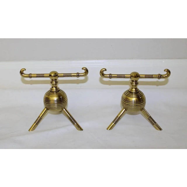 Pair of English Aesthetic Movement brass andirons, attributed Christopher Dresser. Each with ring-turned horizontal bar...