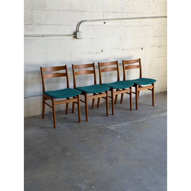 Beautiful set of 4 vintage Danish Mid-Century Modern dining chairs crafted in teak with elegantly curved ladder-back...