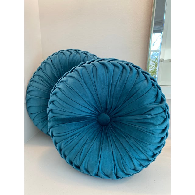 A beautiful pair of round sunburst velvet pillows. Teal in color and features a braided layered rim around the outside.
