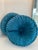 A beautiful pair of round sunburst velvet pillows. Teal in color and features a braided layered rim around the outside.